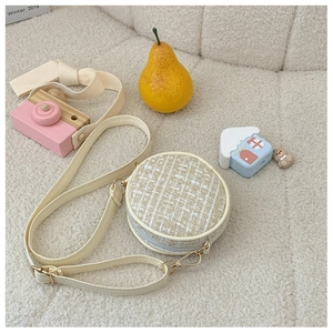 Close-up of a white tweed round crossbody bag for girls with adjustable leather strap