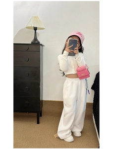Girl's white knitted cardigan and trousers set with pink bow bag and cap detail