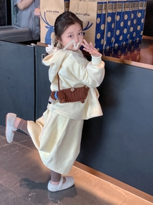 Detail einer handgehäkelten braunen Dackel-Umhängetasche mit einem Fleece-Kinder-Outfit