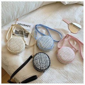Collection of four round tweed crossbody bags for girls in pastel colors on white fabric