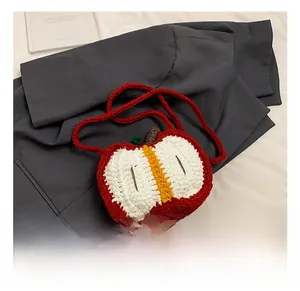 Close-up of handmade crochet apple-shaped crossbody bag featuring detailed knit texture