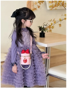 Pink quilted bucket bag for girls with red bow detail and pearl chain shown on model