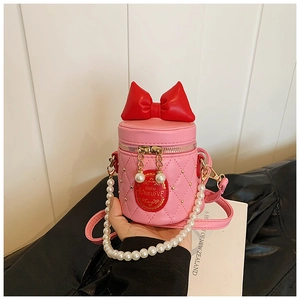 Close-up of pink quilted girl's bucket bag with red bow and pearl chain handle