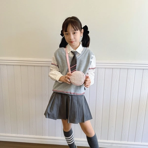Classic preppy style kids school uniform with grey knit vest and white shirt
