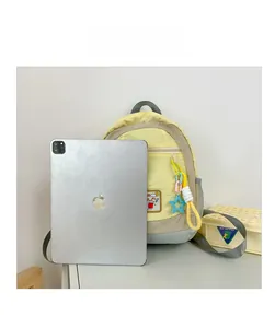 Kids backpack in yellow and gray compared to an iPad for size reference and scale