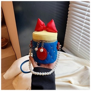 Close-up of kids tricolor bucket bag featuring red bow and pearl chain details