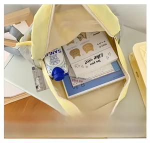 Interior view showing the large capacity of the yellow and grey canvas school backpack