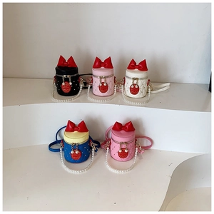 Detail of colorful mini bucket bags for girls with bows and pearl handles in five colors