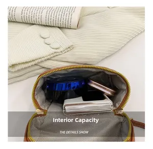 Internal capacity of mini shoulder bag showing space for makeup and digital accessories