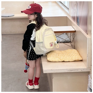 Close-up of lightweight yellow and gray children backpack worn by a young girl
