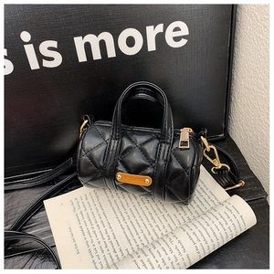 Detailansicht einer schwarzen gesteppten Mini-Zylindertasche mit goldenen Beschlägen