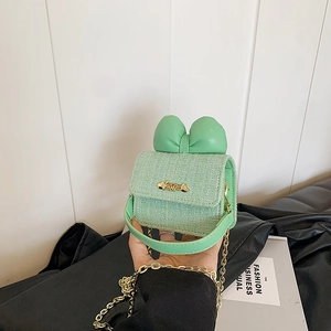 Detail of mint green tweed girl bag with bow and golden Love hardware charm