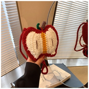 Close-up of handmade crochet apple bag showing detailed red and white knit textures