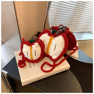 Macro detail of handmade crochet apple bags in two sizes with realistic leaf and stem accents