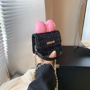 Detail of tweed mini bag with pink leather bow and gold Abnel logo lettering