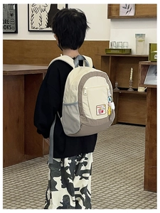 Detailed view of kids school backpack featuring cream and brown canvas with star charm