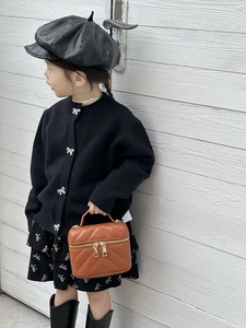 Brown quilted mini crossbody box bag styled with black knitted cardigan and boots