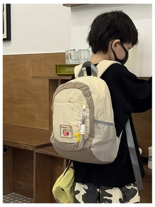 Detail of color-block kids backpack with popcorn embroidery and side mesh pocket