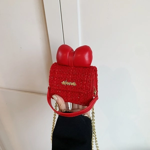 Detail of red tweed mini bag featuring leather bow and golden Love lettering hardware