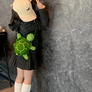 Handmade crochet turtle bag for kids featuring vivid green knit and detailed shell patterns