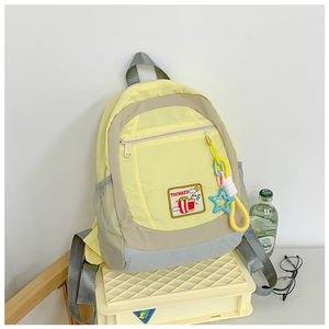 Detail of light yellow school backpack with large capacity and cartoon patch details