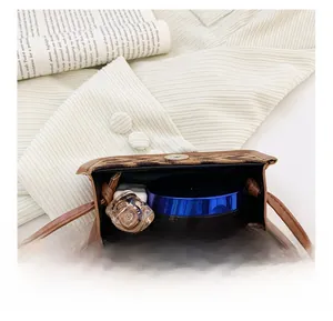 Detailed view of leopard print mini bag interior with magnetic clasp and daily essentials