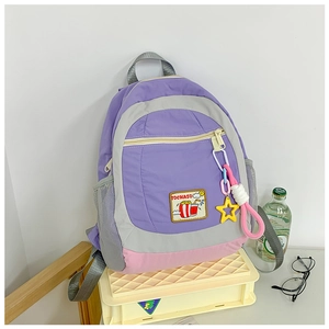 Detail of multi-color children backpack with mesh pocket and star pendant on nylon fabric