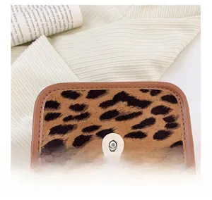 Close-up of leopard print faux fur bag showing magnetic snap closure and leather trim