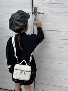 Girl's white quilted mini box bag worn cross-body with adjustable gold chain strap