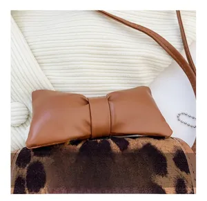 Close-up of girls leopard print handbag with a brown leather bow and golden chain strap