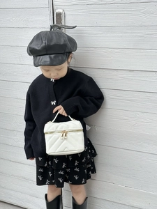 Close-up of white mini quilted leather crossbody bag with dual gold zippers for girls