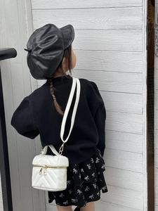 Detail of white quilted mini box bag with gold zipper for kids fashion accessories