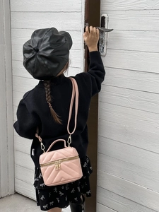 Pink quilted crossbody bag and black leather beret on a child in a minimalist setting