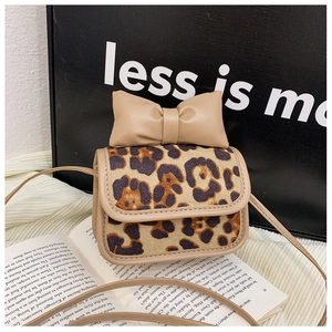 Close-up of leopard print mini bag with leather bow decoration on an open book