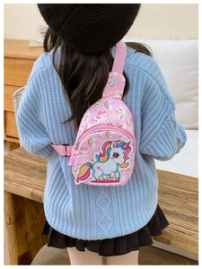 Detailansicht der pinkfarbenen Einhorn-Brusttasche mit Regenbogen-Print an einem Kind