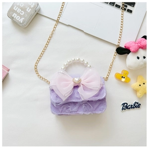 Detail der lila Kinderhandtasche aus Spitze mit großer rosa Schleife und Perlenherz