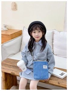 Lifestyle shot of kids denim crossbody bag with fashion label and adjustable strap