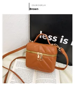 Brown mini quilted V-pattern handbag with gold zipper and top handle shown on props