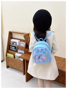 Detail of light blue girls backpack with bow and mermaid design on child model