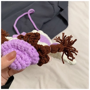 Détail d'un sac au crochet violet montrant la texture du tricot et des nattes tressées