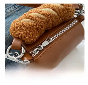 Detail of creative plush baguette handle and brown cylinder bag with cute bear charm