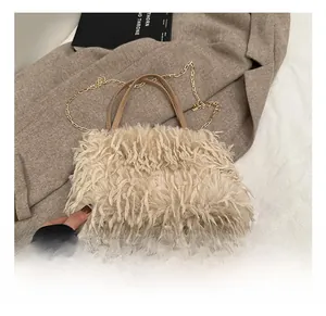 Detail of cream faux fur handbag showing leather handle and gold chain strap texture