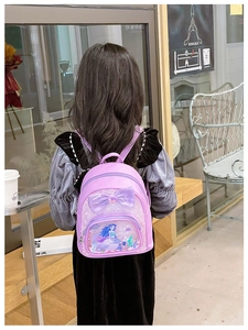 Detail of purple toddler backpack with large bow and mermaid sequins on little girl