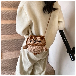 Detail of a handmade crochet lion bucket bag worn by a child on a minimalist staircase