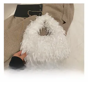 Détail de la texture pelucheuse blanche et de la chaîne dorée du sac à bandoulière