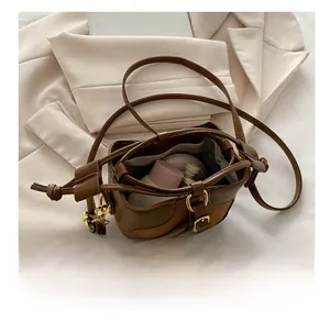 Detail view showing the spacious interior of the leather bucket bag with makeup items