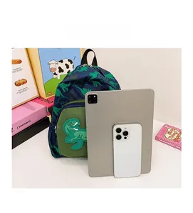Confronto dimensioni tra zaino per bambini con dinosauri e tablet con smartphone