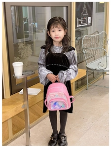 Girl holding pink backpack featuring a velvet bow and mermaid glitter detail