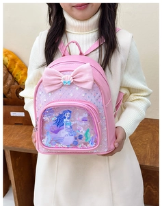 Detail of glitter mermaid girl pattern and pink bow on kid backpack for school