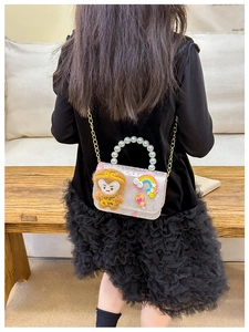 Detail view of pink glitter kids bag with monkey plush and decorative pearl handle
